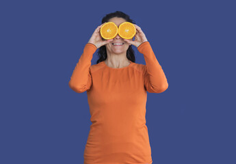 Brunette woman with oranges on her face wearing orange t-shirt