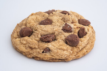 Close up of a classic chocolate chip cookie. Famous and ubiquitous cookie made with candy chocolate chips. Texture and macro shot of a cookie 
