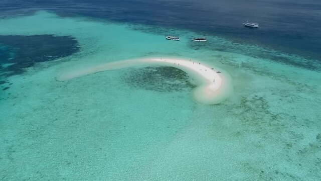 Manta ray Point. Wild islands of Indonesia. Flores. tropical paradise. Labuan Bajo. Wild beaches, blue lagoons, coral reefs. aerial drone view. boat trip safari. a group of people on a desert island