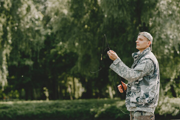 A man fishing on a lake. Guy in a uniform.