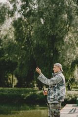 A man fishing on a lake. Guy in a uniform.