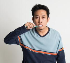 Fototapeta premium Asian guy brushing teeth 
