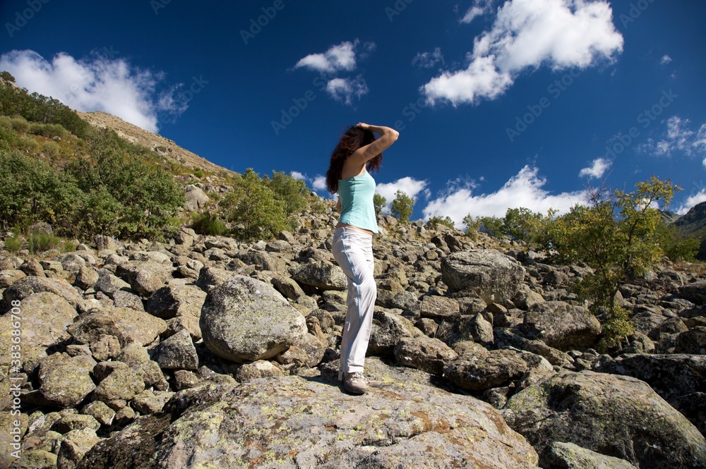 Wall mural woman on ocean of rocks