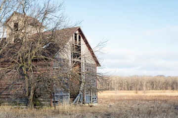 Old and Dilapidated Wood Barn in a Field in Winter