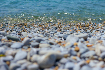 Pebble sea shore. Pebble beach and turquoise sea water
