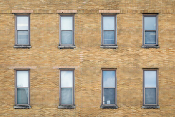 Exterior Wall of a Brown Brick Building with Eight Windows