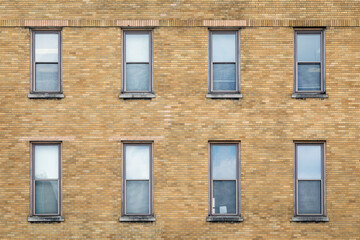 Obraz premium Exterior Wall of a Brown Brick Building with Eight Windows