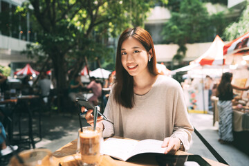 Business freelancer adult asian woman using mobile phone for work at sidewalk cafe