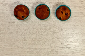 Three ruddy baked Easter cakes, muffins with raisins. In a horizontal row up frame.