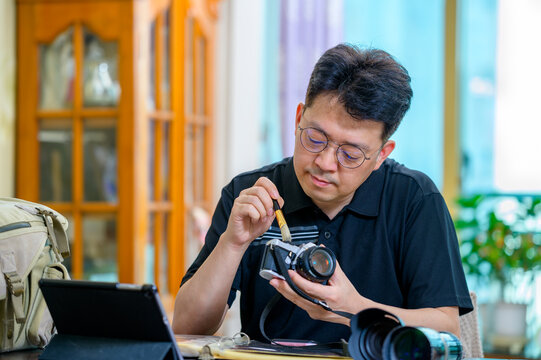 A middle-aged Asian man whose hobby is 35mm/135mm film SLR camera. - Powered by Adobe