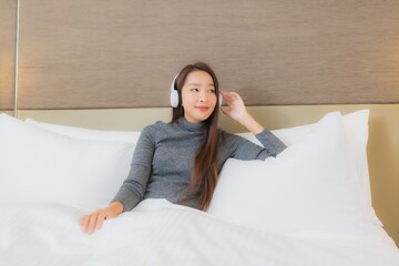 Obraz premium Portrait beautiful young asian woman use headphone for listen music on bed