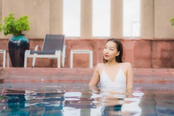 Fototapeta na wymiar Portrait beautiful young asian woman relax smile leisure around outdoor swimming pool