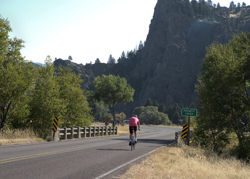 Cyclist on a bright day ride in hilly Montana country.