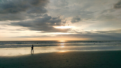 Fototapeta na wymiar A woman taking picture from the beauty of Petitenget beach Bali Indonesia.