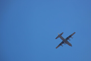 hercules plane flying high in the bright blue sky