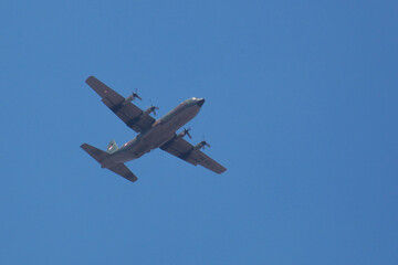 hercules plane flying high in the bright blue sky