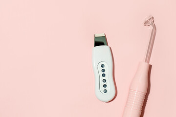 Ultrasonic peeling and dorsanvales device with modes on pink background, minimal beautycian concept, home salon procedure, wellness, skincare, self-insulation