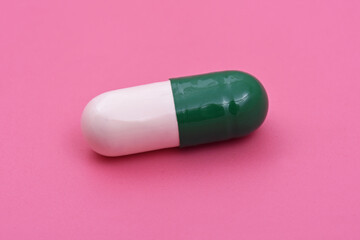 White green capsule Pharmaceutical medicine tablet on pink background,  Flat lay. Copy space. Medicine concepts. Minimalistic abstract concept. baby pink color background