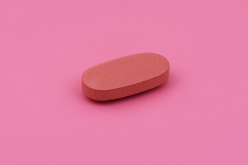 Oval shape Pharmaceutical medicine tablet on pink background,  Flat lay. Copy space. Medicine concepts. Minimalistic abstract concept. baby pink color background