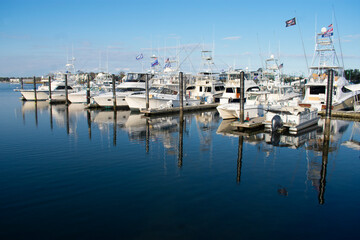 Fototapeta na wymiar Motorboats lining the docks in a marina in Belmar, New Jersey, on a beautiful sunny day. -02