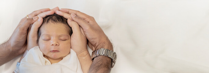 Close up father and mother hands holding newborn baby, copy space background banner family parents love concept