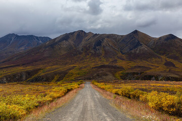 View of Scenic Road and Mountains on a Cloudy Fall Day in Canadian Nature. Taken near Tombstone Territorial Park, Yukon, Canada.