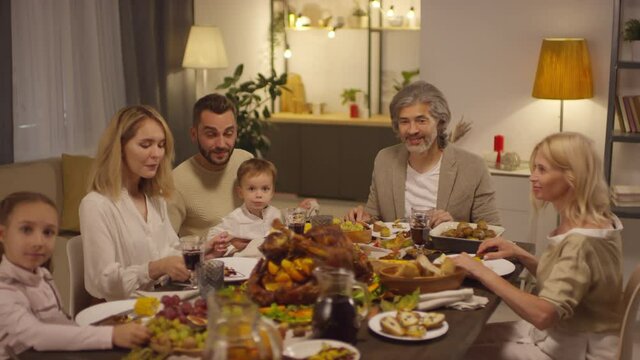 Slow motion shot footage of modern big family gathered together on Thanksgiving day having dinner