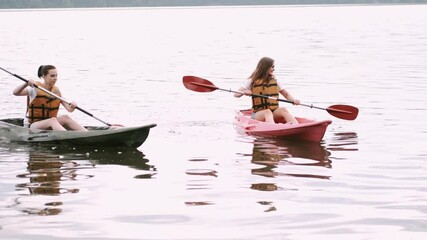 Kayaking and canoeing with friends. Girlfriends on canoe. Friends on kayak ride.