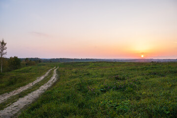 Fototapeta na wymiar Road leading to the field, a beautiful red sunset.