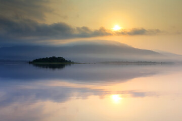 Light morning with fog on the lake at sunrise