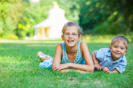 Little boy and his sister in the summer park