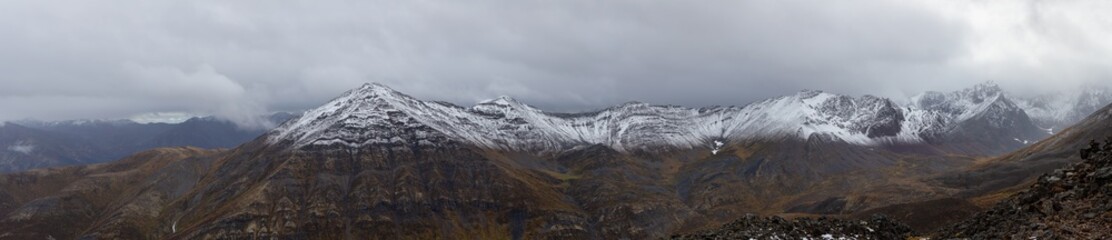 Panoramic View of Scenic Landscape and Mountains in Canadian Nature. Season change from Fall to Winter. Taken in Tombstone Territorial Park, Yukon, Canada.