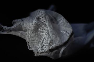 primer plano de ropa interior femenina bombacha y corpiño en su confección con hilos maquina de coser con  base oscura