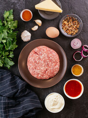 fresh raw minced pork in a wooden bowl with vegetables on the ba