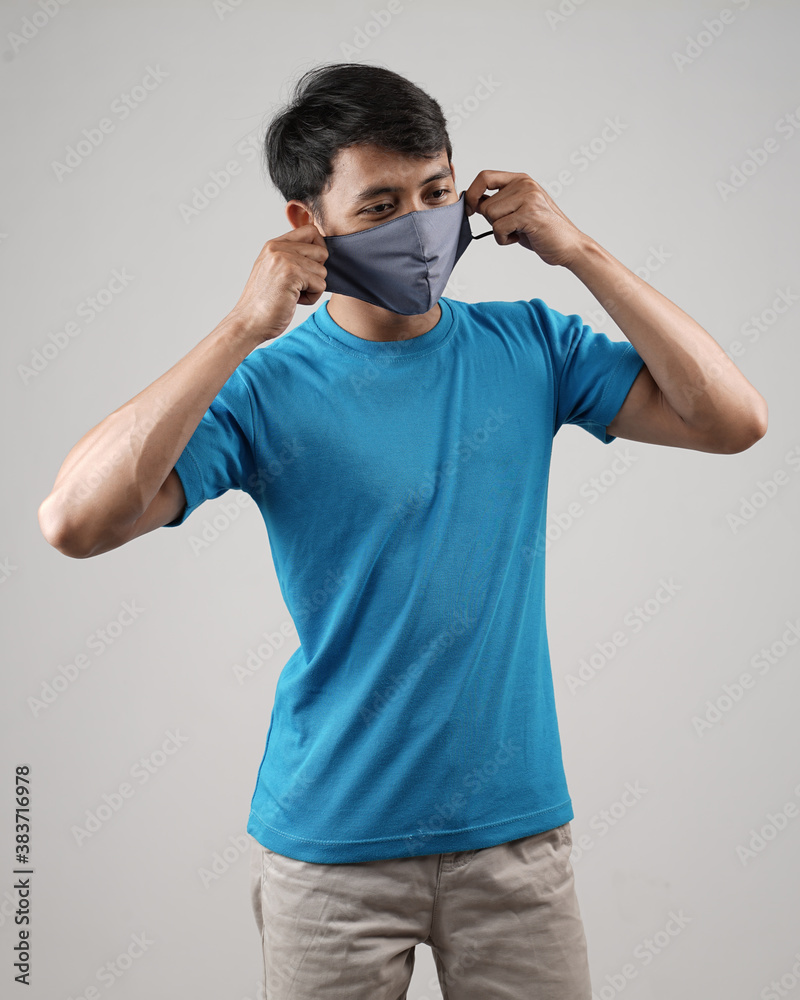 Wall mural Young men in empty T-shirts and wearing health masks, dress up and pose like famous T-shirt models. Men's t-shirt template and mockup design for print.