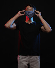 Fototapeta premium Young men in empty black T-shirts and wearing health masks, dress up and pose like famous T-shirt models. Men's t-shirt template and mockup design for print.