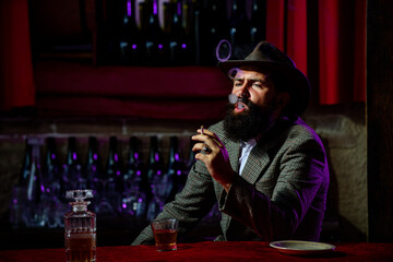 Attractive man smoking cigarettes with glass of wiskey.