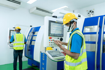 Supervisor or Worker use tablet to control computerized lathe machine in the metalwork factory. Caucasian technician engineer operating CNC milling cutting machine in manufacturing workshop. 