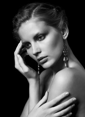 Obraz premium Black and white portrait of young beautiful woman on black