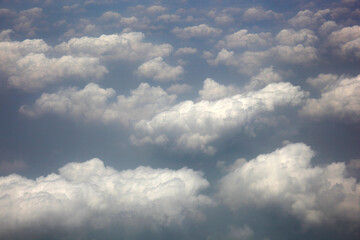 Dramatic sky with fluffy clouds. View from plane window.