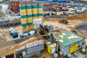 A concrete mixer truck transports concrete through a construction site.