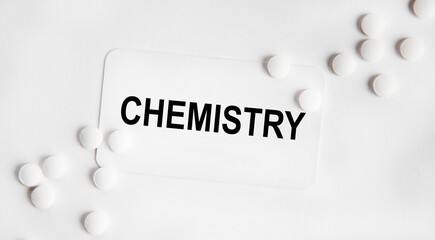 on the business card text CHEMISTRY, next to the white tablets.