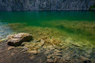 lake with green algae water between the walls of the mountain