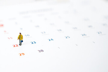 Miniature people of businessman standing on white calendar. Weekend time concept with copy space for your text or design.