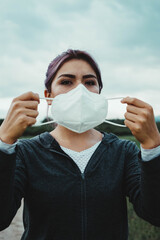 woman in sportswear putting on a mask