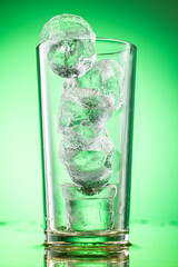 pieces of pure real ice in a glass on a colored gradient background, cubes are rounded