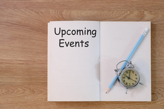 Concept Upcoming Events message on notebook with clock and pencil on wooden table. - Powered by Adobe