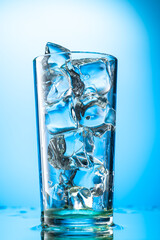pieces of pure real ice in a glass on a colored gradient background, cubes are rounded