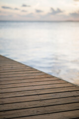 Fototapeta premium Timber deck platform with blue water ocean in the background and sky clouds