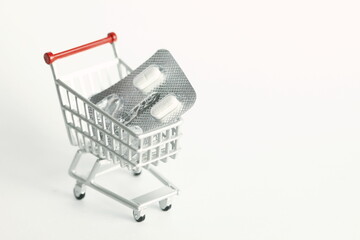 Miniature shopping cart model and medicine scene represent medical and treatment business concept related idea.